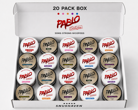 An open white Pablo Exclusivo 20-pack box containing 20 small round nicotine pods with various colored labels, displayed on a clean white background.